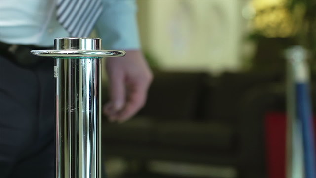 Close-up of unrecognizable man opening velvet rope to let person through. Crowd control, VIP access, event management. Suitable for hospitality, security, exclusive events visuals