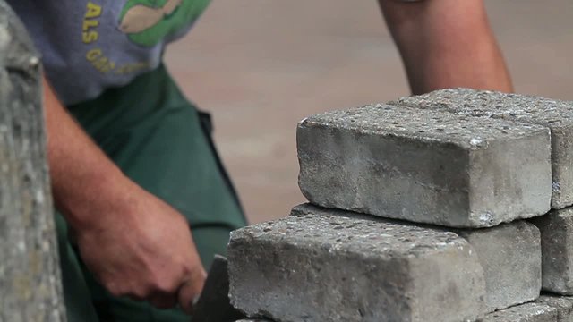 Construction worker is cleaning bricks with a spattle