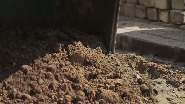Digger shovels sand, roadworks