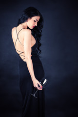 beautiful woman in a black dress with a glass in hand