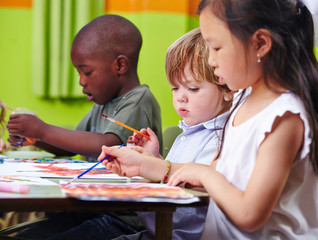 Kinder malen zusammen Bilder im Kindergarten - obrazy, fototapety, plakaty