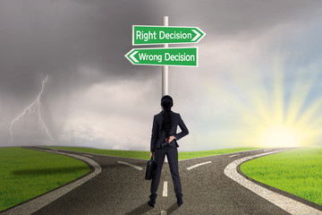 Businesswoman looking at sign of right vs wrong decision