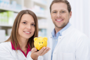 mitarbeiter in der apotheke mit sparschwein