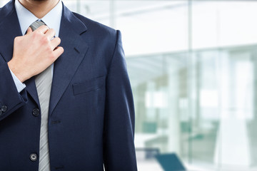 Businessman adjusting his necktie