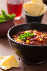 mexican chili con carne in black plate with tortilla
