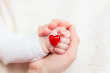 hands of mother and baby holding heart - 61309199