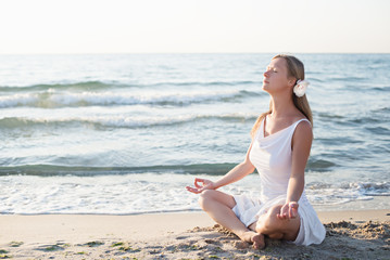 Fototapeta na wymiar Young woman meditation on the beach
