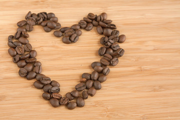 Сердце из кофейных зерен на деревянном фоне