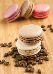 Макаруны и кофейные зерна на деревянном фоне