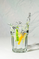 Lime and lemon water splash in glass