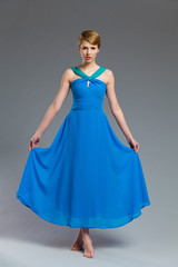 Fashion model posing in blue dress.