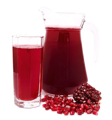 Pomegranate juice in pitcher and pomegranates isolated on white