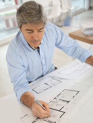 Architect working on blueprint in office
