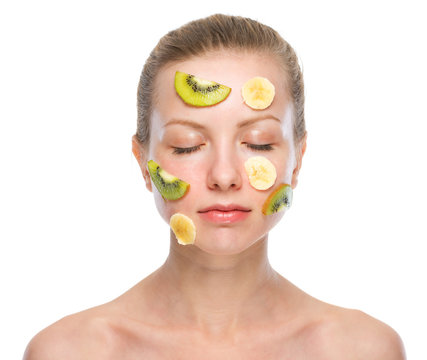 Portrait of relaxed young woman making fruits mask