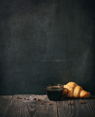 coffee and croissant on blackboard background. copy space