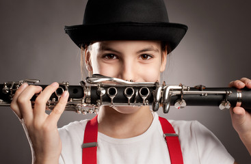 little girl playing clarinet - obrazy, fototapety, plakaty