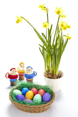 Korb mit bunten Ostereiern und Osterglocken