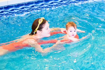 Young mother with a little baby in the swimming pool