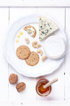 Cheese plate. Various types of cheese with honey and nuts.