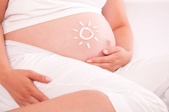 Belly of pregnant woman with sun symbol on it