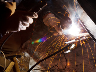 car repairs by welding in field at night