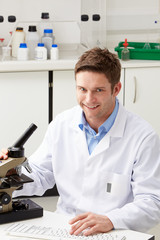 Portrait Of Scientist With Microscope In Laboratory