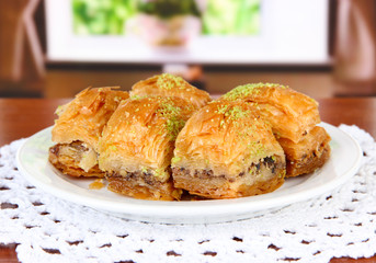 Sweet baklava on plate on table in room