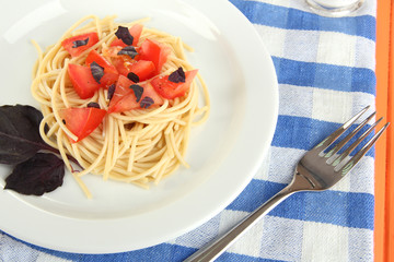 Spaghetti with tomatoes and basil leaves