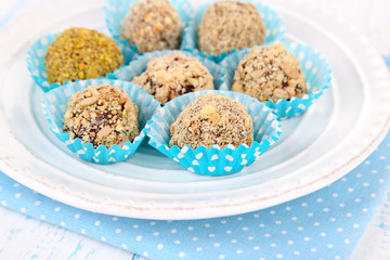 Set of chocolate candies, on plate, on wooden background
