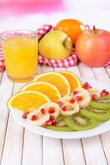 Sweet fresh fruits on plate on table close-up
