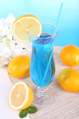 Glass of cocktail on table on light blue background