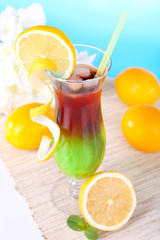 Glass of cocktail on table on light blue background