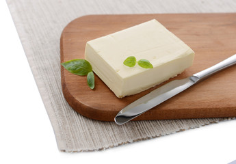Tasty butter on wooden cutting board isolated on white