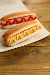 Tasty hot dogs on wooden table