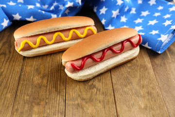 Tasty hot dogs on wooden table