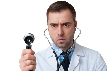 Serious male doctor holds stethoscope in hand on white backgroun