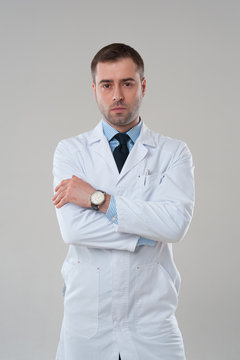Portrait of mature serious male doctor with crossed arms