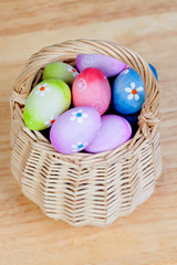 Easter eggs decorated with daisies tucked in a basket
