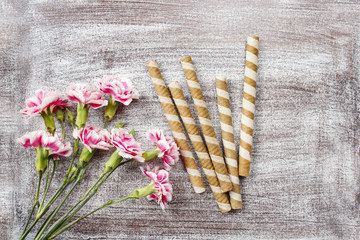 Striped wafer rolls, delicious chocolate snack and bouquet