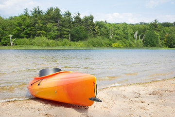 Kayak on lake beach near woods