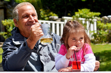 Grandfather drinks with his grandchild