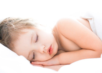 Fototapeta na wymiar Cute baby girl is sleeping on white bed