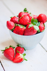 Closeup of strawberries in a bowl on wooden backgorund