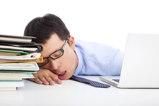 young businessman too weary to asleep on the desk