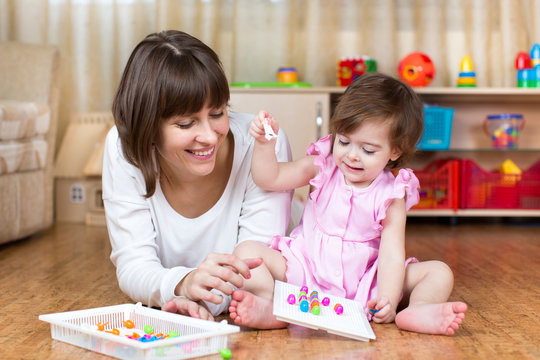 mother and kid play together in home interior