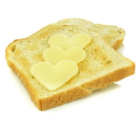 Toast with heart shaped cheese slices on white background