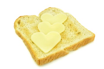 Toast with heart shaped cheese slices on white background