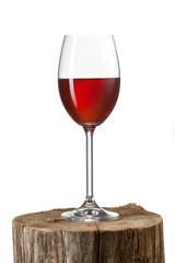 Glass of red wine on stump isolated on white