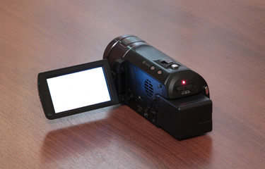 high-definition camera with white screen on a wooden background