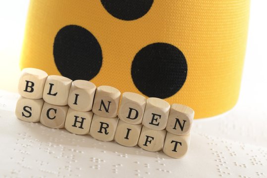 Holzw&uuml;rfel mit Armbinde und Blindenschrift